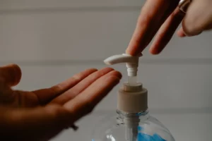 an image of a hand pressing the hand sanitiser